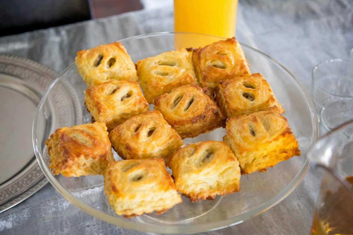 Delicious golden puff pastries arranged on a clear glass plate, perfect for dessert or snack.